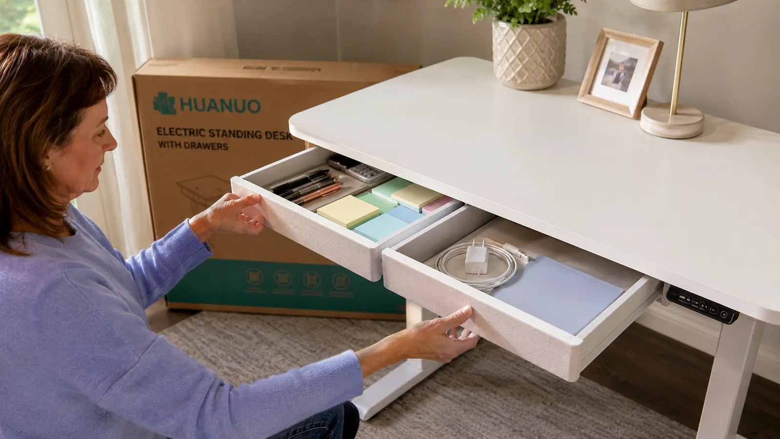 HUANUO electric standing desk with two drawers slightly open showing organized office supplies inside
